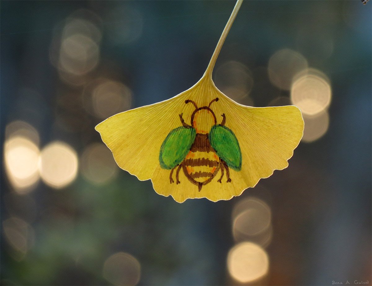 A striped bumblebee with green wings drawn on a yellow ginkgo leaf against soft blue and gold bokeh, by Sera Autumn