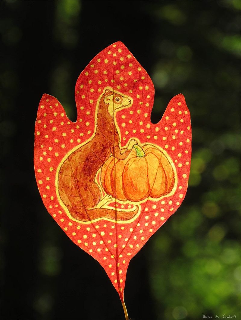 A brown ferret beside an orange pumpkin, drawn on a red polka-dotted leaf against dark green forest, by Sera Autumn