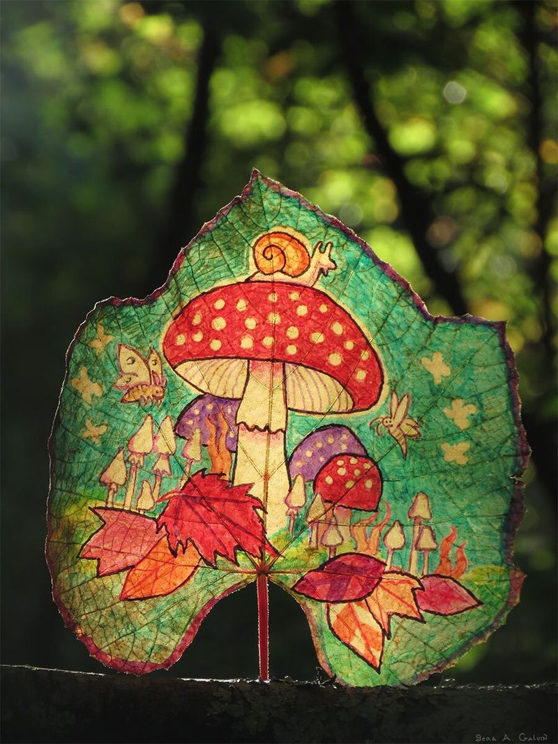 A red polka-dot mushroom with a snail on top, butterfly and toadstools, drawn on a green grape leaf against sunlit forest, by Sera Autumn