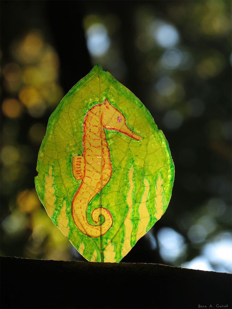 An orange seahorse curling among green seaweed, drawn on a translucent backlit leaf against dark forest bokeh, by Sera Autumn