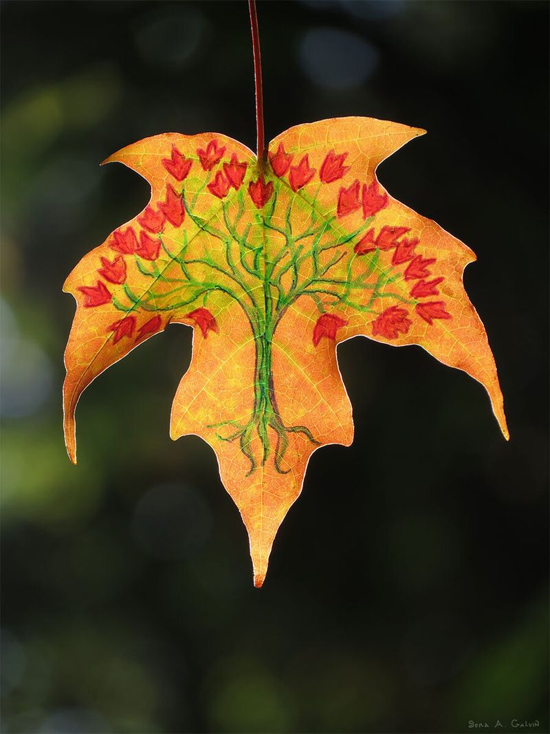 A green tree with red leaves and roots drawn on a golden-orange maple leaf against dark bokeh, by Sera Autumn