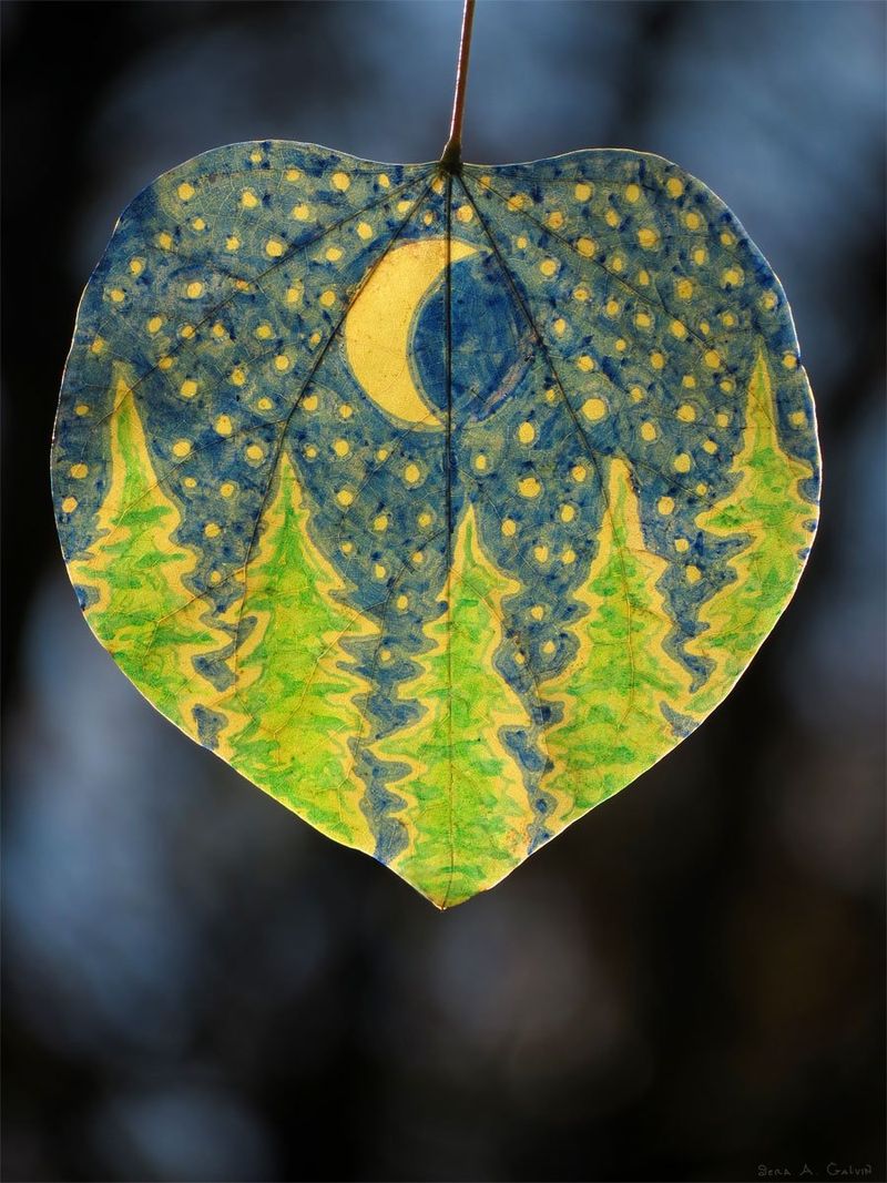 A crescent moon, stars, and green pine trees drawn on a blue heart-shaped leaf in a night scene, by Sera Autumn